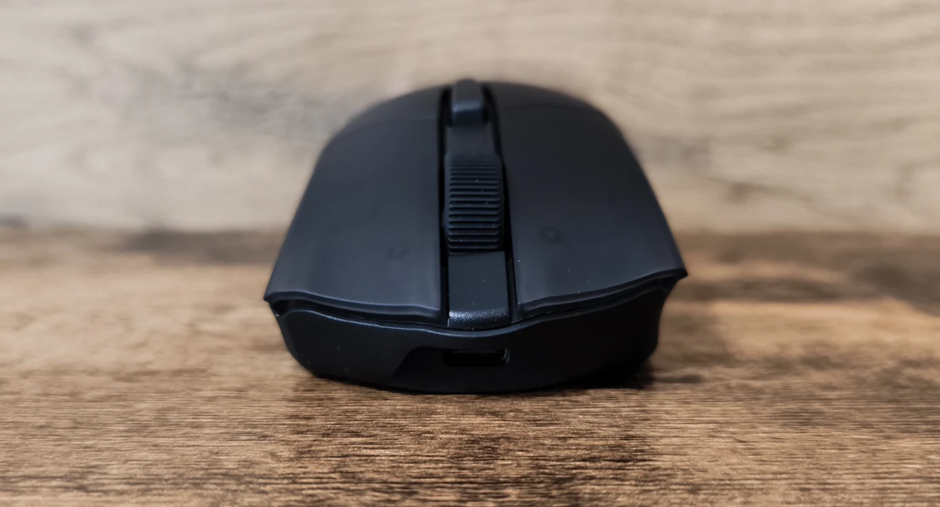 Corsair Harpoon V2 Wireless Czarna bezprzewodowa mysz komputerowa ustawiona na drewnianym blacie, widok od przodu z wyraźnie widoczną rolką przewijania.