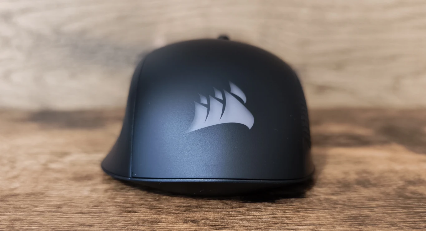 Corsair Harpoon V2 Wireless Czarna mysz komputerowa z logo producenta na matowej powierzchni, ustawiona na drewnianej powierzchni.