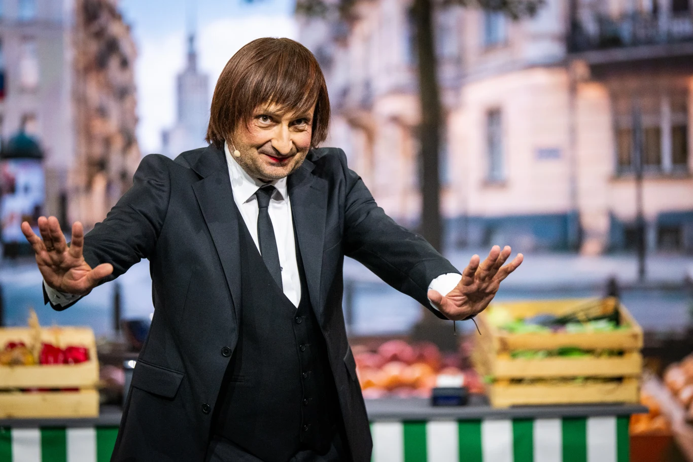 Robert Górski założył perukę, sceniczny kostium i przeistoczył się w Izabelę Trojanowską Robert Górski w peruce i kostiumie jako Izabela Trojanowska przy stoisku z warzywami w mieście
