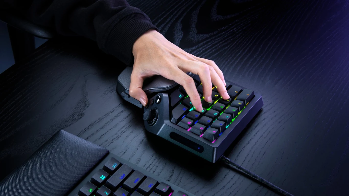 Razer Tartarus V2 Pro Dłoń na specjalistycznej klawiaturze gamingowej z podświetleniem RGB, ustawionej na czarnym biurku.