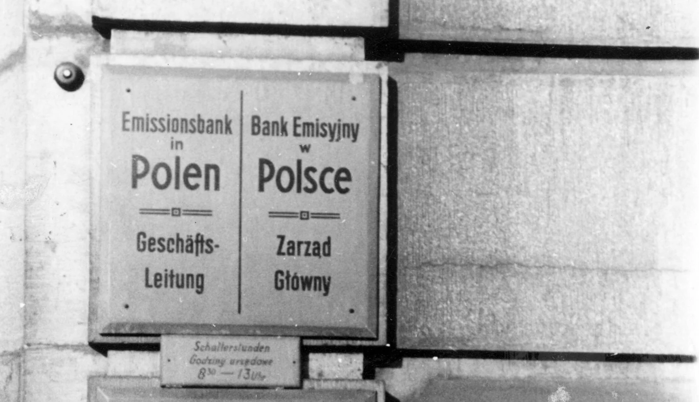 Tablica informacyjna na ścianie z napisem Bank Emisyjny w Polsce w języku polskim i niemieckim oraz informacją o Zarządzie Głównym.