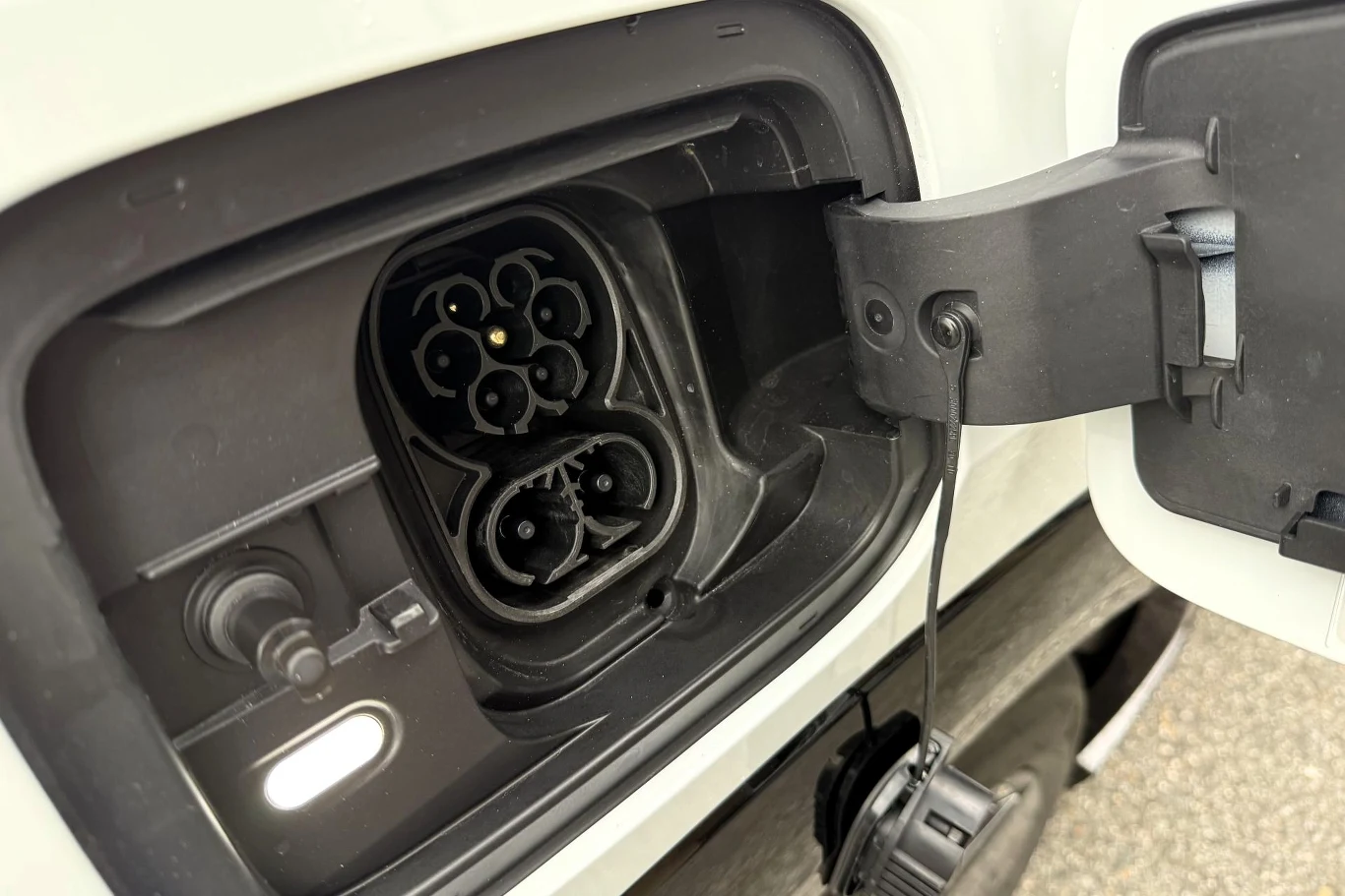 Na jednym ładowaniu Skoda Peaq przejedzie do 640 km. Gniazdo ładowania samochodu elektrycznego typu CCS z otwartą klapką ochronną.