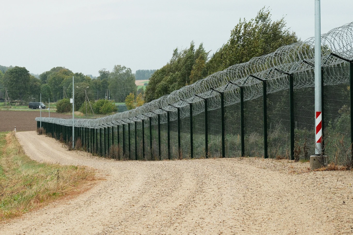 Wysokie ogrodzenie z drutem kolczastym na granicy Estonii i Rosji w pobliżu miejscowości Vinski.