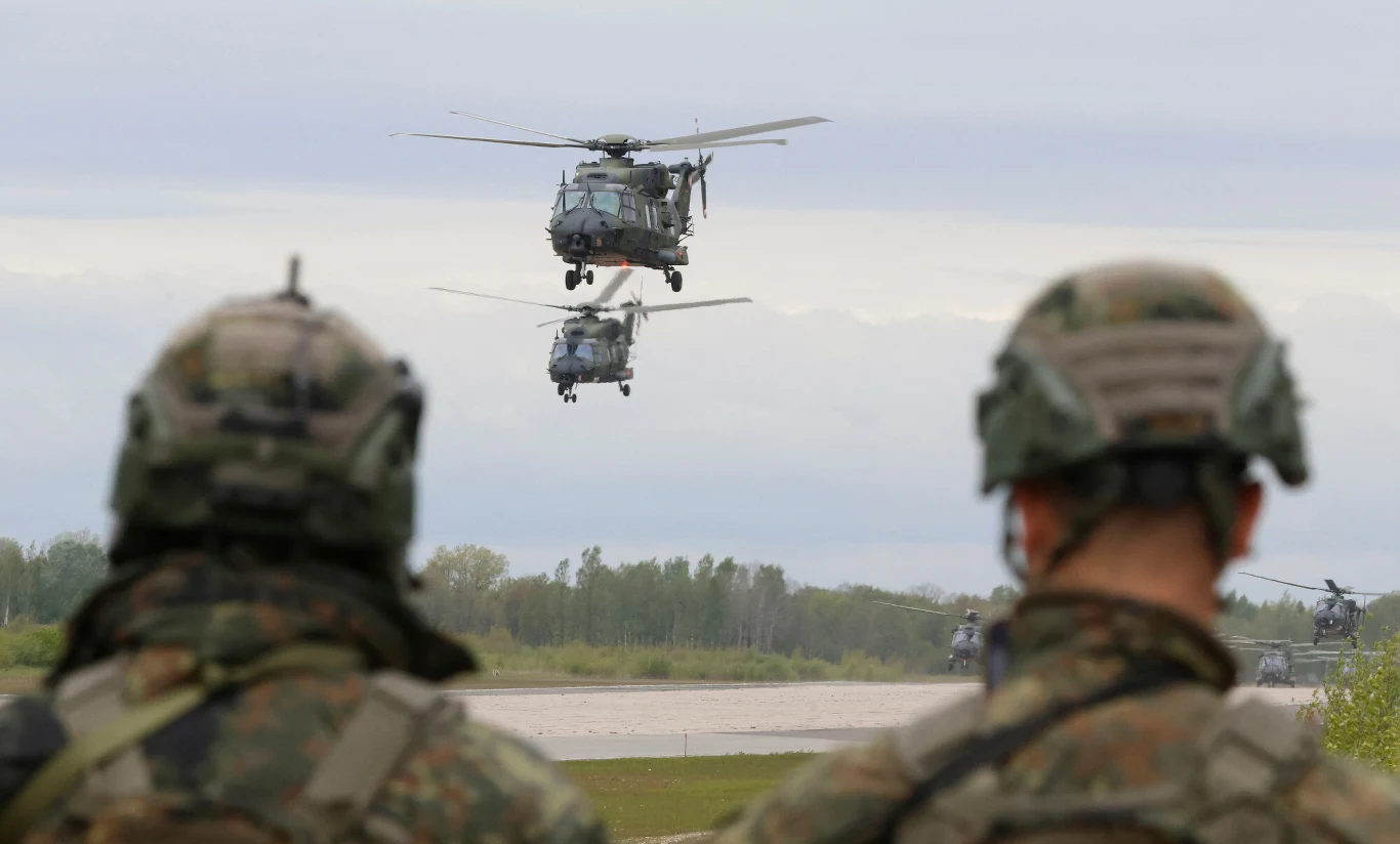 Ćwiczenia NATO na Litwie. Niemieckie śmigłowce i żołnierze Żołnierze obserwują niemieckie śmigłowce wojskowe podczas ćwiczeń NATO Griffin Lightning 2025 na Litwie.