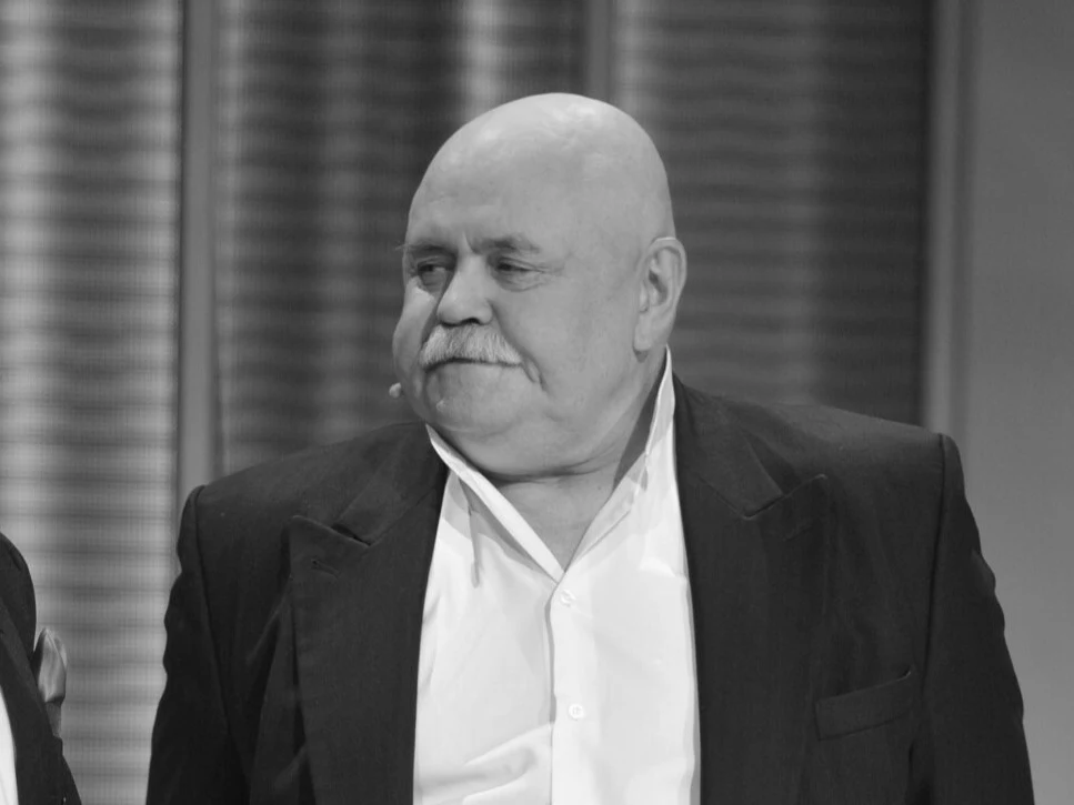 Stanisław Szelc Łysy mężczyzna z wąsami w ciemnej marynarce i jasnej koszuli stoi w lekko przekręconej pozycji, patrząc w bok