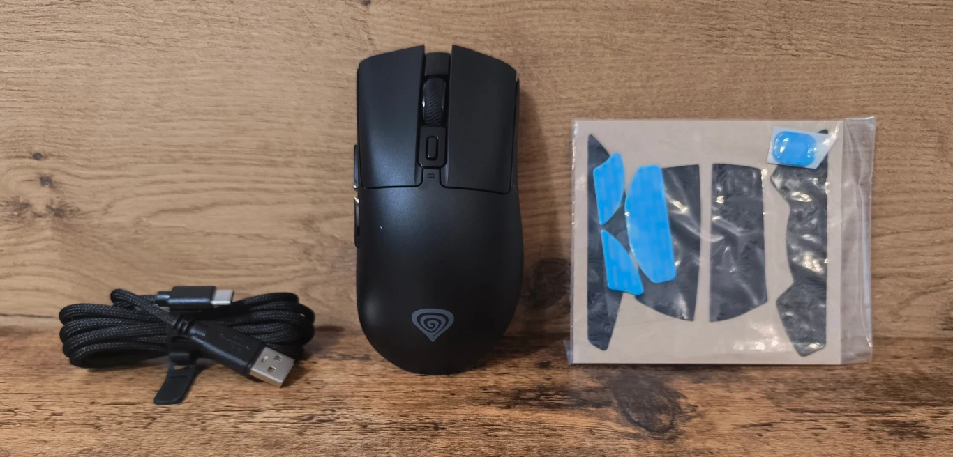 Czarna mysz komputerowa z dodatkowym zestawem gripów i odłączanym przewodem USB leżące na drewnianej powierzchni.