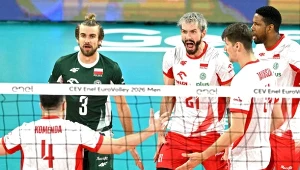Polscy siatkarze w trakcie emocjonującej wymiany na boisku podczas meczu turnieju EuroVolley, wśród nich wyróżniają się zawodnicy w białych i czerwonych strojach wyrażający silne emocje oraz libero w zielonym stroju.