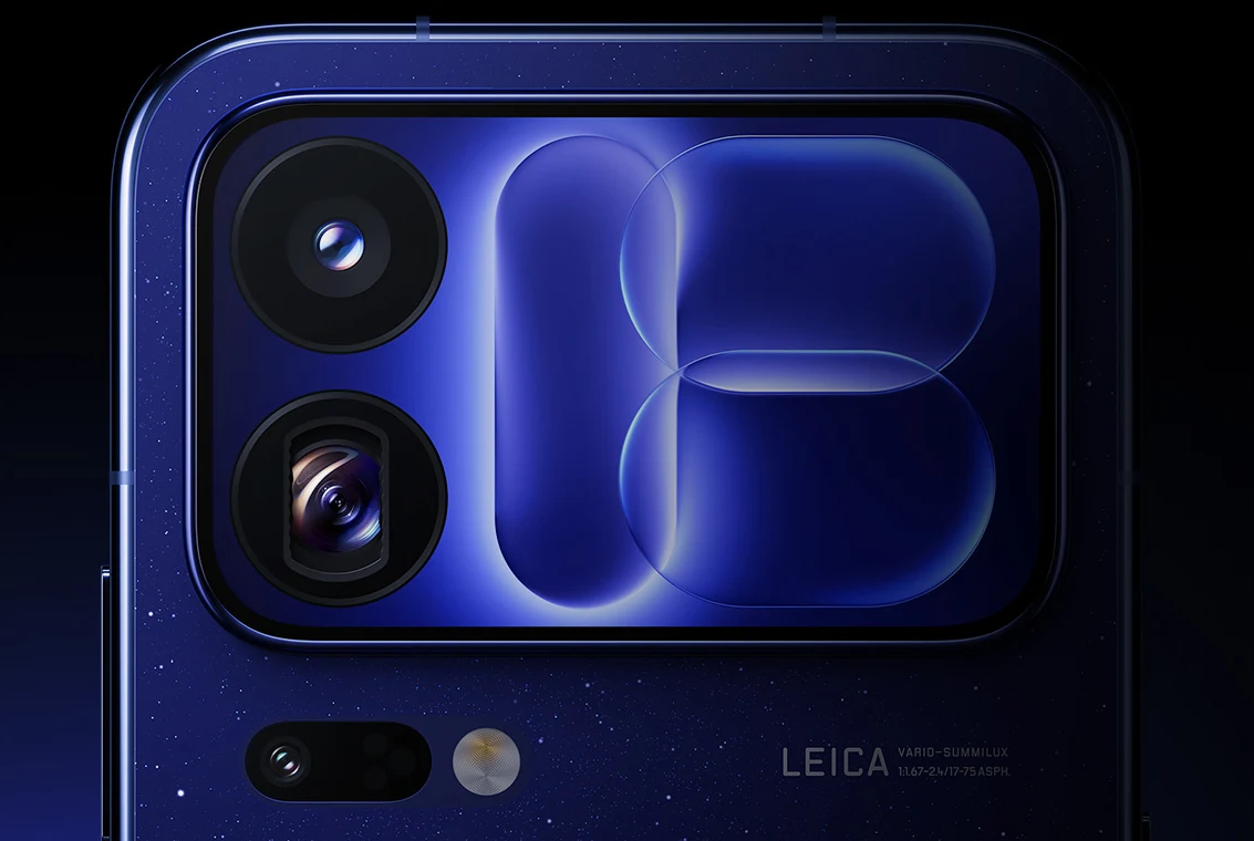 Zbliżenie na moduł aparatów smartfona z dwiema kamerami, dużą szklaną powierzchnią ochronną i logotypem Leica w dolnej części obudowy.