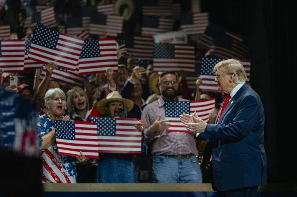 Donald Trump na konwencji republikanów w Dallas Donald Trump w garniturze klaszcze na scenie podczas konwencji republikanów w Dallas, tłum z flagami USA.