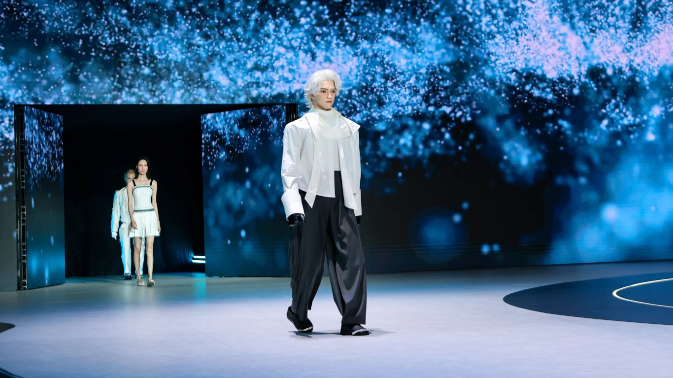 U1 opisywano jako "UWORLD U1 – pierwszego na świecie pełnowymiarowego, produkowanego masowo ultrabionicznego robota humanoidalnego". Model ubrany w luźne, szerokie czarne spodnie, biały golf i krótką białą kurtkę idzie po wybiegu, a za nim podąża dwóch innych modeli w jasnych stylizacjach, na tle futurystycznej, błękitnej scenografii.