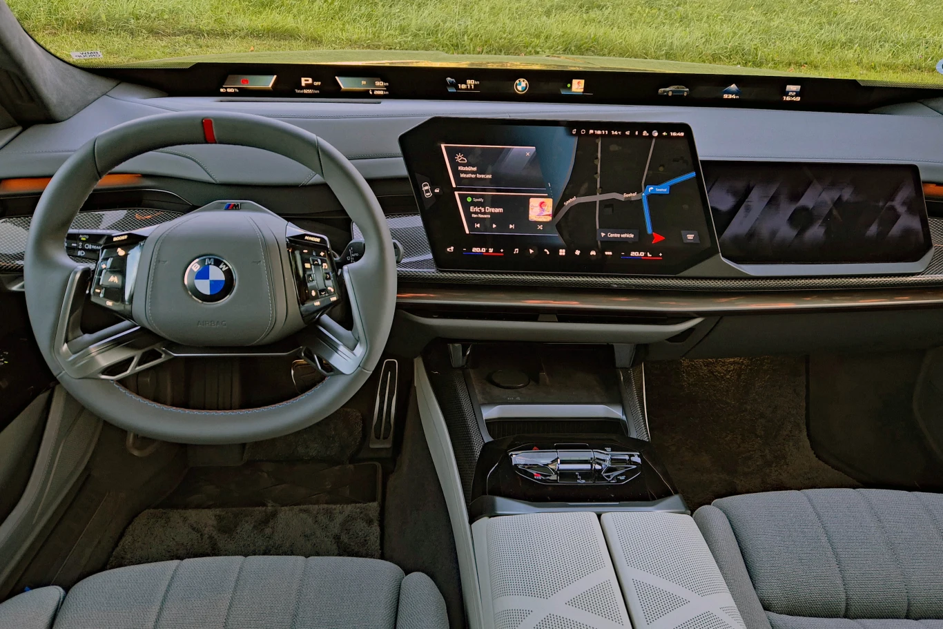 BMW serii 7 ma teraz deskę rozdzielczą typową dla modeli Neue Klasse Nowoczesna deska rozdzielcza z cyfrowymi wyświetlaczami, wielofunkcyjna kierownica z logo BMW, centralny dotykowy ekran multimedialny z nawigacją oraz komfortowe, jasne fotele wykończone materiałową tapicerką.