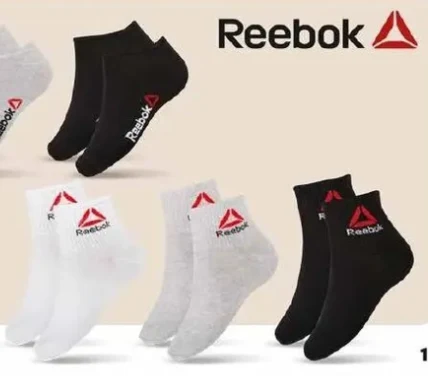 Czarne, białe i szare skarpetki Reebok z widocznym logo marki w kolorze czerwonym i czarnym, ułożone w parach na jasnym tle.