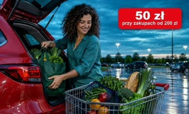 Kobieta przekłada warzywa i pieczywo z wózka do bagażnika czerwonego auta na parkingu o zmierzchu
