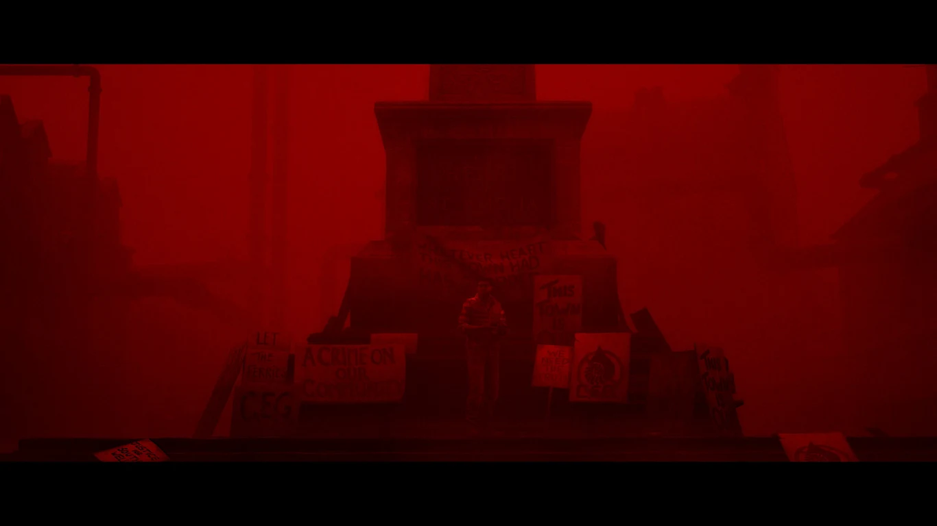 Silent Hill: Townfall Postać stojąca samotnie na tle dużego pomnika, otoczona transparentami i plakatami, scena skąpana w intensywnym, czerwonym świetle.