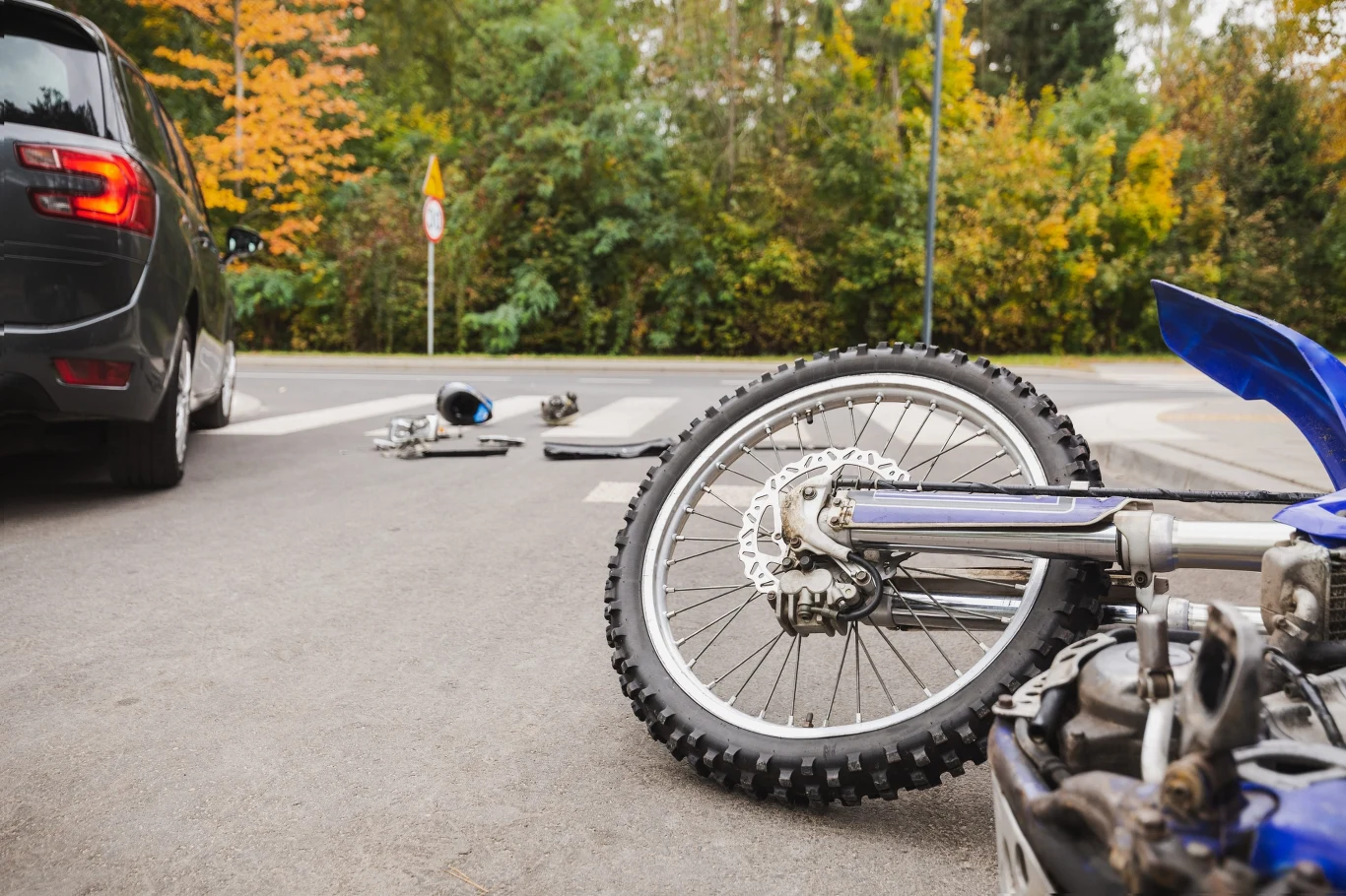 Kierowcy muszą zachować szczególną ostrożność. Motocykl może znaleźć się w tzw. martwym polu. Motocykl leżący na asfalcie, kask i części motocykla obok samochodu na skrzyżowaniu po zderzeniu.