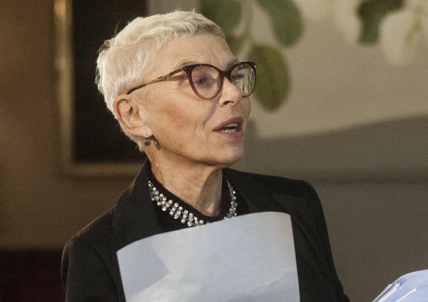 Hanna Bieluszko Hanna Bieluszko, aktorka znana z serialu M jak miłość, w czarnym stroju z naszyjnikiem i okularach.