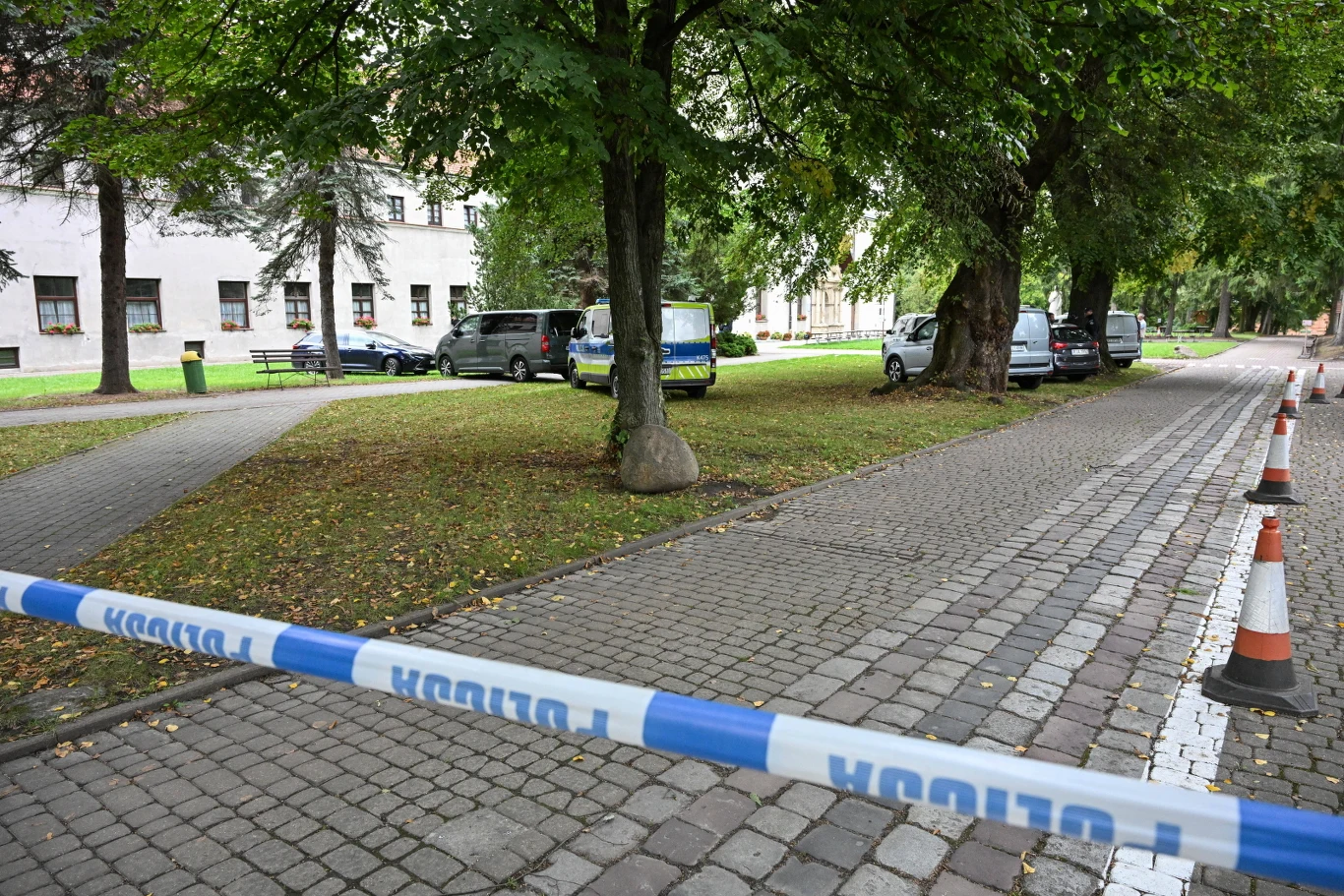 Trzymiesięczny areszt dla Ihora M. Policyjna taśma odgradzająca chodnik, zaparkowane auta pod drzewami przy budynku mieszkalnym w Jarosławiu.