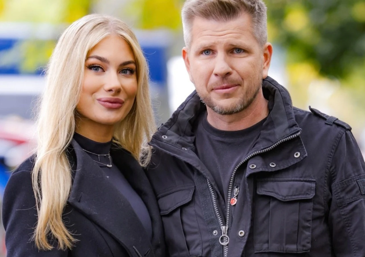 Filip Chajzer i jego żona Bianka Chajzer Para ubrana w ciemne ubrania stoi razem na zewnątrz, patrząc wprost do obiektywu.