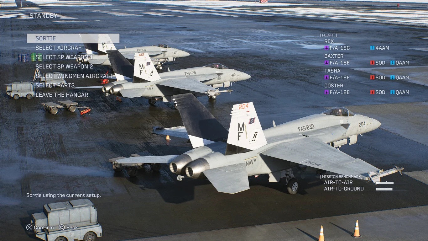 Myśliwiec F/A-18E z biało-szarym malowaniem stoi na płycie lotniska, a w tle widoczne są dwa inne samoloty tego samego typu ustawione w rzędzie.
