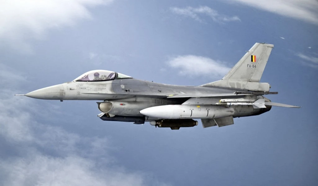 Belgia przekaże Ukrainie do końca tego roku trzy myśliwce F-16 Belgijski myśliwiec F-16 z oznaczeniem narodowym, uzbrojony, w locie na tle nieba z chmurami.