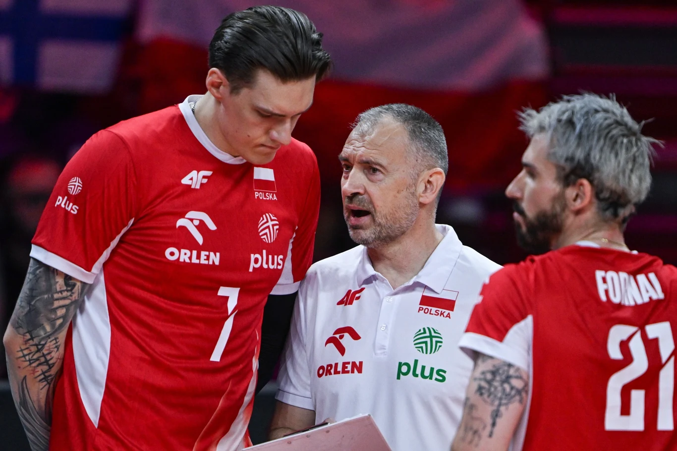 Nikola Grbić w czasie ostatniego sezonu korzystał z nowych przepisów. Teraz częśćz nich znajdzie zastosowanie w Polsce Trzech mężczyzn w sportowych strojach drużyny siatkarskiej Polski podczas rozmowy na boisku, jeden z nich trzyma tablicę taktyczną.