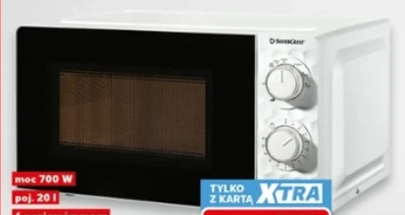 Biała kuchenka mikrofalowa z dużym, czarnym frontem i dwiema pokrętłami sterującymi po prawej stronie obudowy, oznaczenia dotyczące mocy i pojemności oraz widoczna informacja o promocji z kartą XTRA.