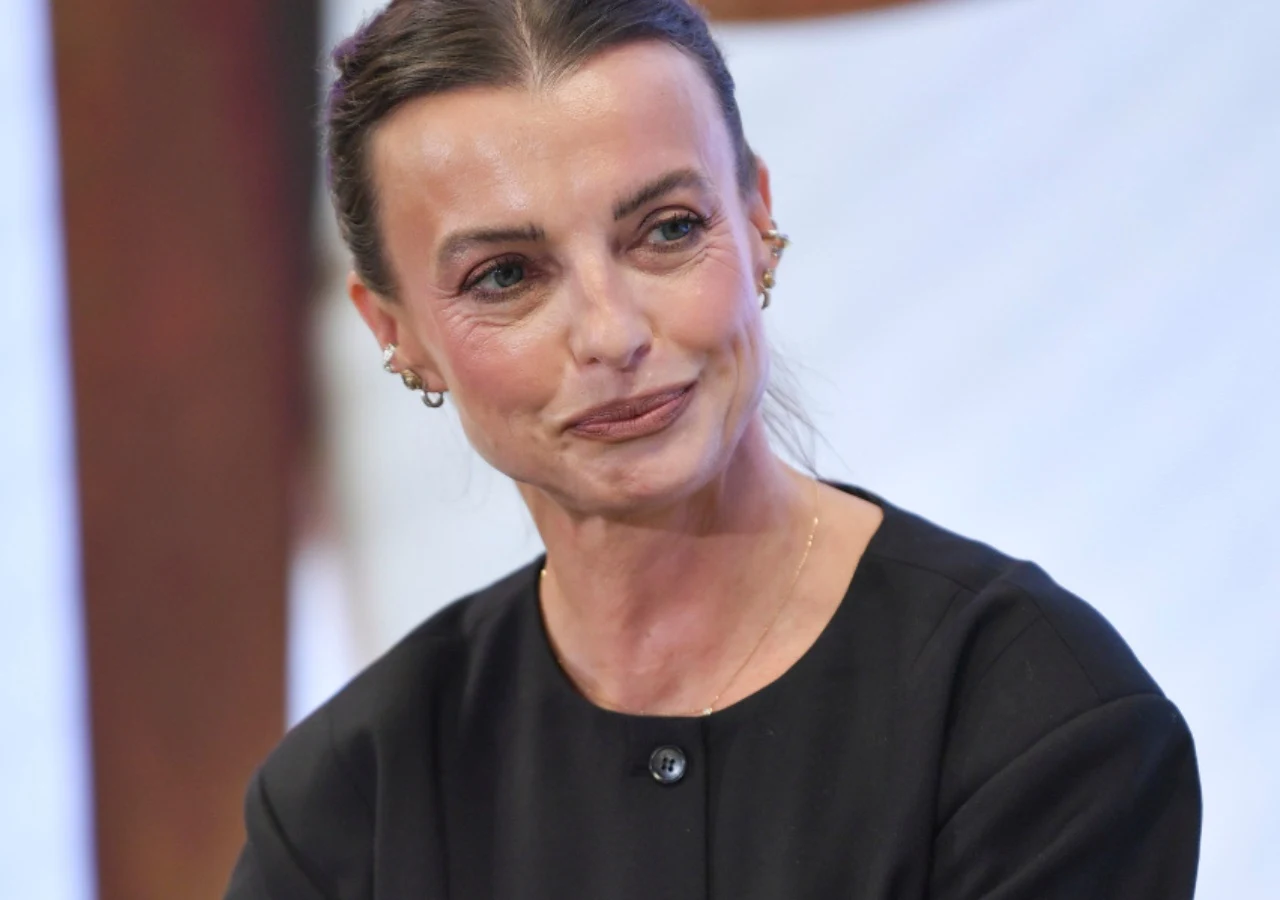 Katarzyna Sokołowska Katarzyna Sokołowska, jurorka Top Model, w czarnym stroju, siedząca w jasnym otoczeniu.