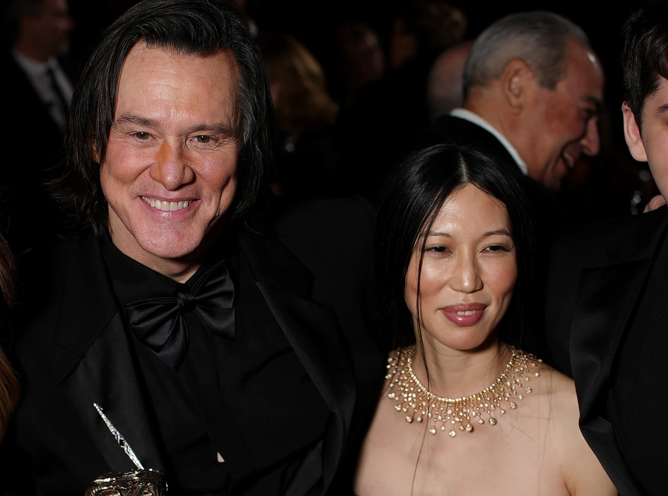 Jim Carrey i Min Ah Jim Carrey w smokingu z muchą i Min Ah w jasnej sukni z naszyjnikiem, pozują razem podczas uroczystości.