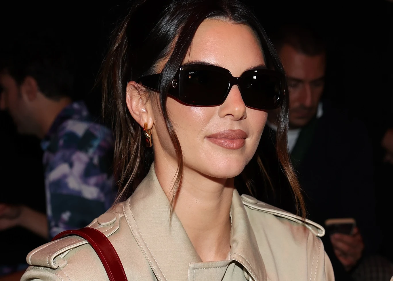 Kendall Jenner jest fanką beżowych płaszczy. To modowy klasyk idealny na każdą okazję Kendall Jenner w beżowym płaszczu, z ciemnymi włosami, okularach i bordową torebką na ramieniu