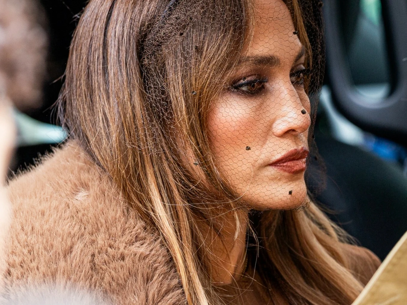 Jennifer Lopez stawia na koloryzację "honey brown". Odmładza i dodaje twarzy blasku Jennifer Lopez w długich, jasnobrązowych włosach 'honey brown', z futrem i koronkową woalką w czarne kropki.