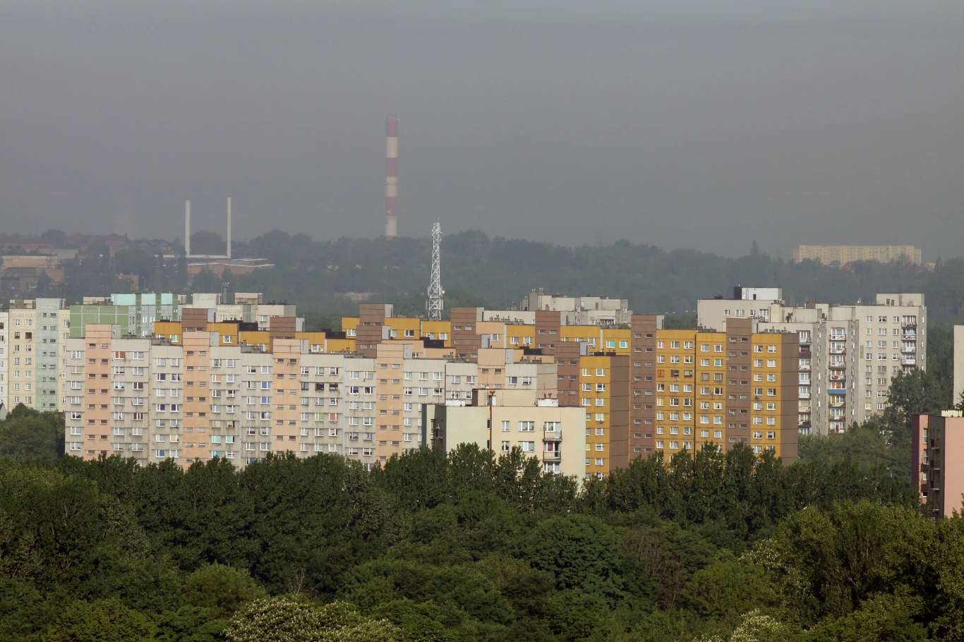 Mieszkańcy Rudy Śląskiej wybrali inwestycje na 2027 rok Bloki mieszkalne w Rudzie Śląskiej, otoczone zielenią, w tle kominy przemysłowe.