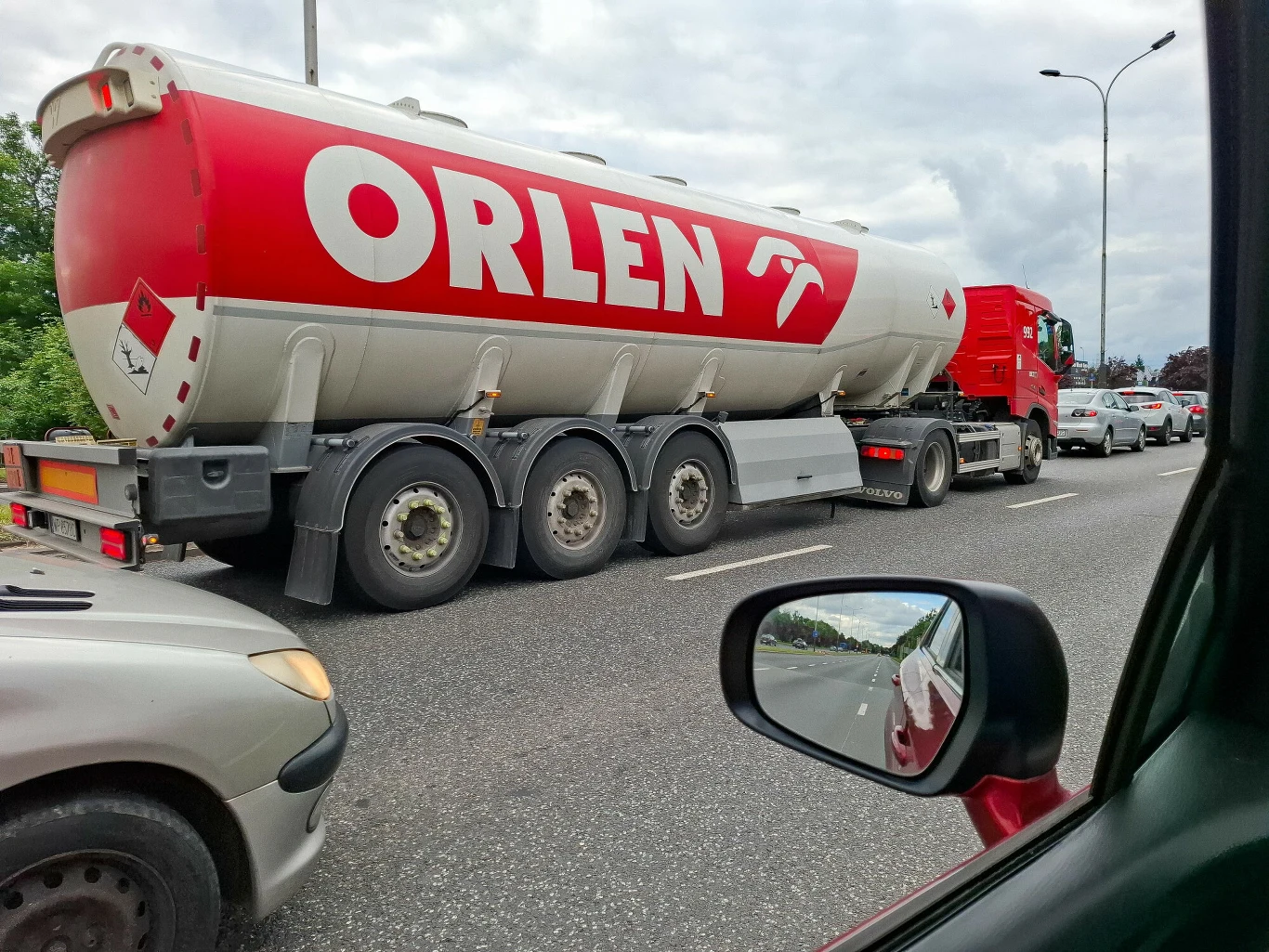Orlen obniża hurtowe ceny paliw. Poczujemy to w kieszeniach w przyszłym tygodniu Cysterna ORLEN na ruchliwej ulicy wśród samochodów osobowych, widoczny korek