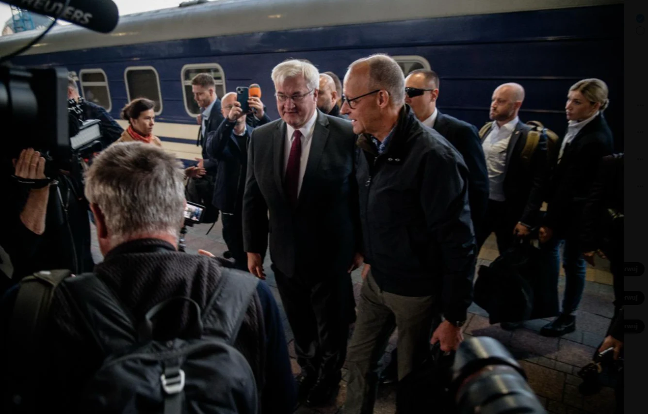 Friedrich Merz w Kijowie, zdjęcie opublikowane w mediach społecznościowych przez Andrija Sybihę, szefa ukraińskiego MSZ (na fot. po lewej) Friedrich Merz i Andrij Sybiha idą obok ciemnoniebieskiego pociągu, w otoczeniu dziennikarzy i fotoreporterów