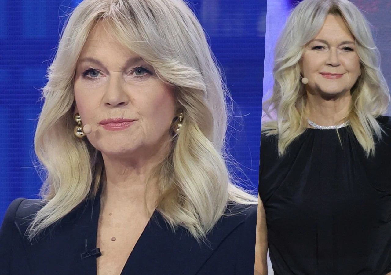 Grażyna Torbicka olśniła na gali Nike Kobieta o blond włosach w średnim wieku, w eleganckiej granatowej i czarnej kreacji, z delikatnym makijażem oraz złotymi kolczykami, uśmiecha się subtelnie, stojąc na tle niebieskiego tła studyjnego.
