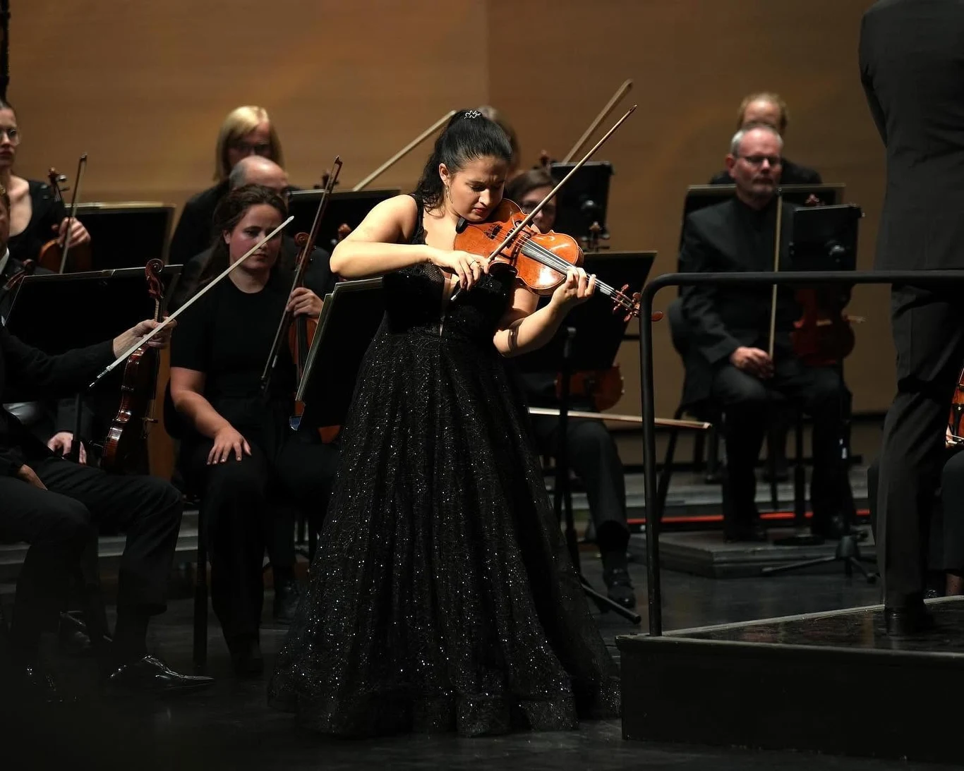 Dolnośląskie. Sara Dragan zagra mistrzowski recital w Legnicy Sara Dragan w czarnej sukni gra solo na skrzypcach przed orkiestrą kameralną na scenie w Legnicy