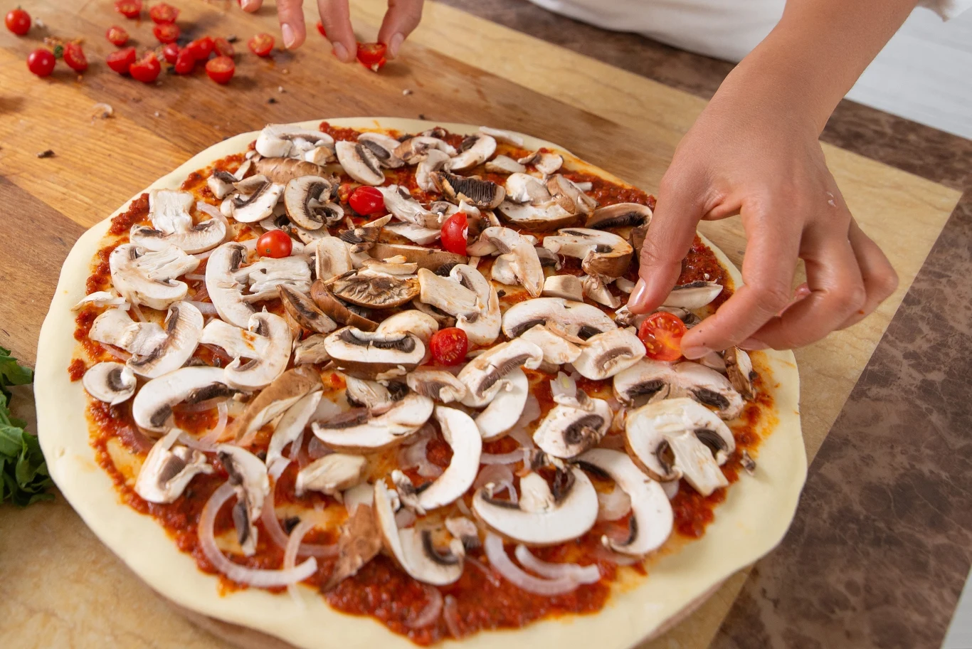 Domowa pizza, która smakuje jak z włoskiej restauracji. Zrobisz ją szybciej, niż zakupy w osiedlowym sklepiku Domowa pizza z sosem pomidorowym, pieczarkami, cebulą i pomidorkami przed włożeniem do piekarnika.