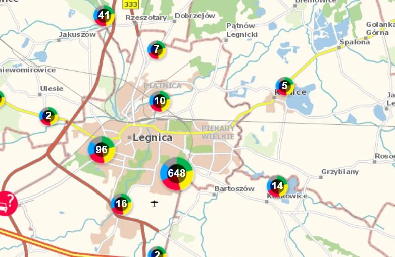 Mapa okolic Legnicy z zaznaczonymi okrągłymi wskaźnikami o różnych liczbach i kolorach, sugerującymi liczbę zgłoszeń lub zdarzeń w wybranych lokalizacjach, największe skupisko widoczne w centrum miasta z liczbą 648.