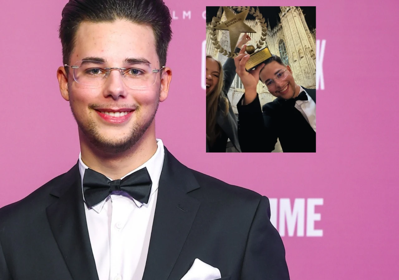 Allan Enso Młody mężczyzna w eleganckim garniturze i muszce uśmiecha się do kamery, w tle różowa ścianka z jasnymi napisami, a na wstawionym zdjęciu trzyma statuetkę w kształcie gwiazdy, stojąc obok uśmiechniętej kobiety na tle gotyckiej katedry.
