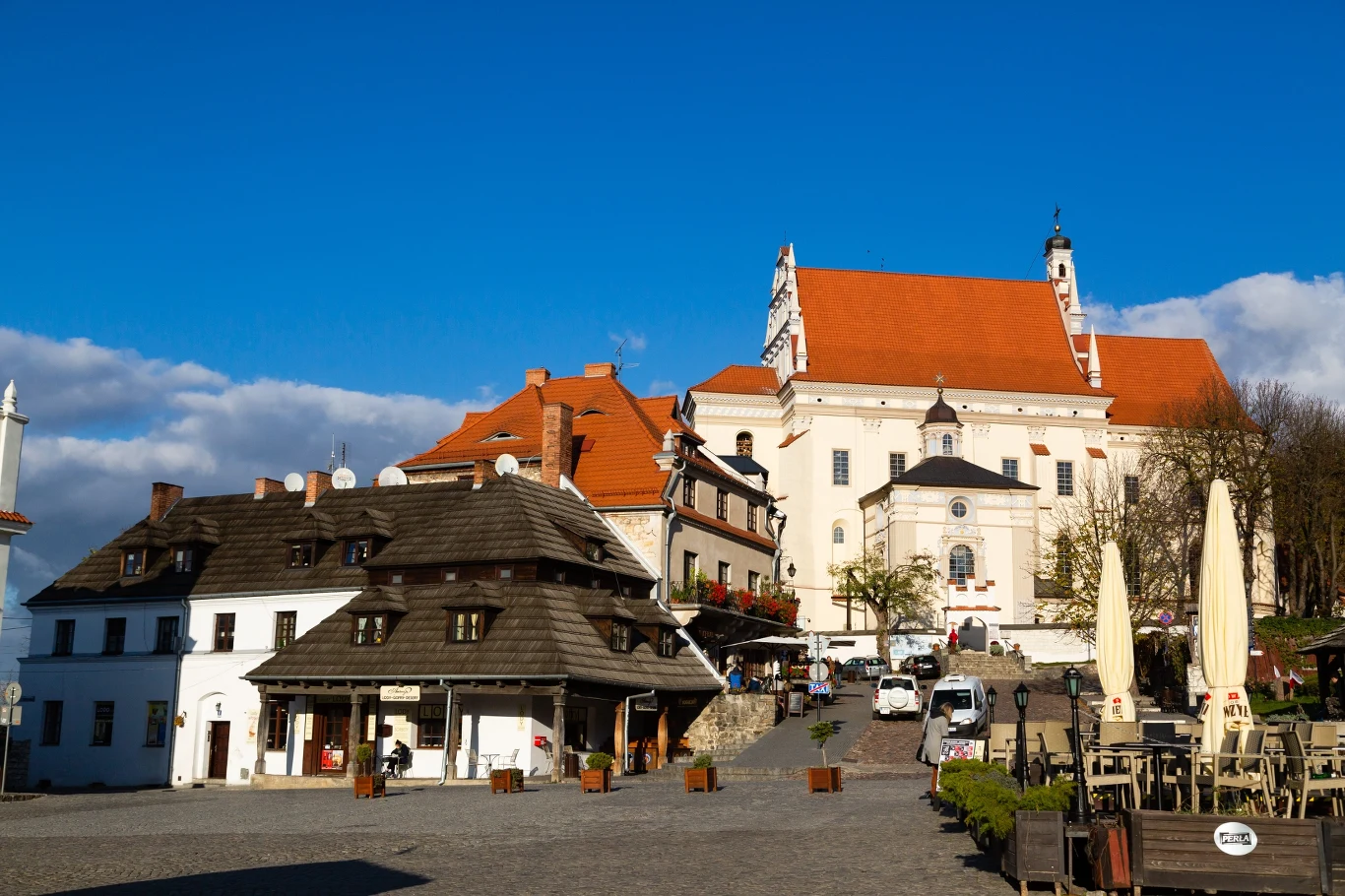 Kazimierz Dolny to dobry kierunek na jesienny wyjazd Zabytkowy rynek w Kazimierzu Dolnym z kościołem i kamienicami.