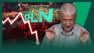 Mężczyzna z siwymi włosami wykonujący gesty rękami na tle wykresu przedstawiającego gwałtowny spadek wartości polskiego złotego oraz zielonych liter PLN, w tle rozmazane stoły do gry hazardowej.