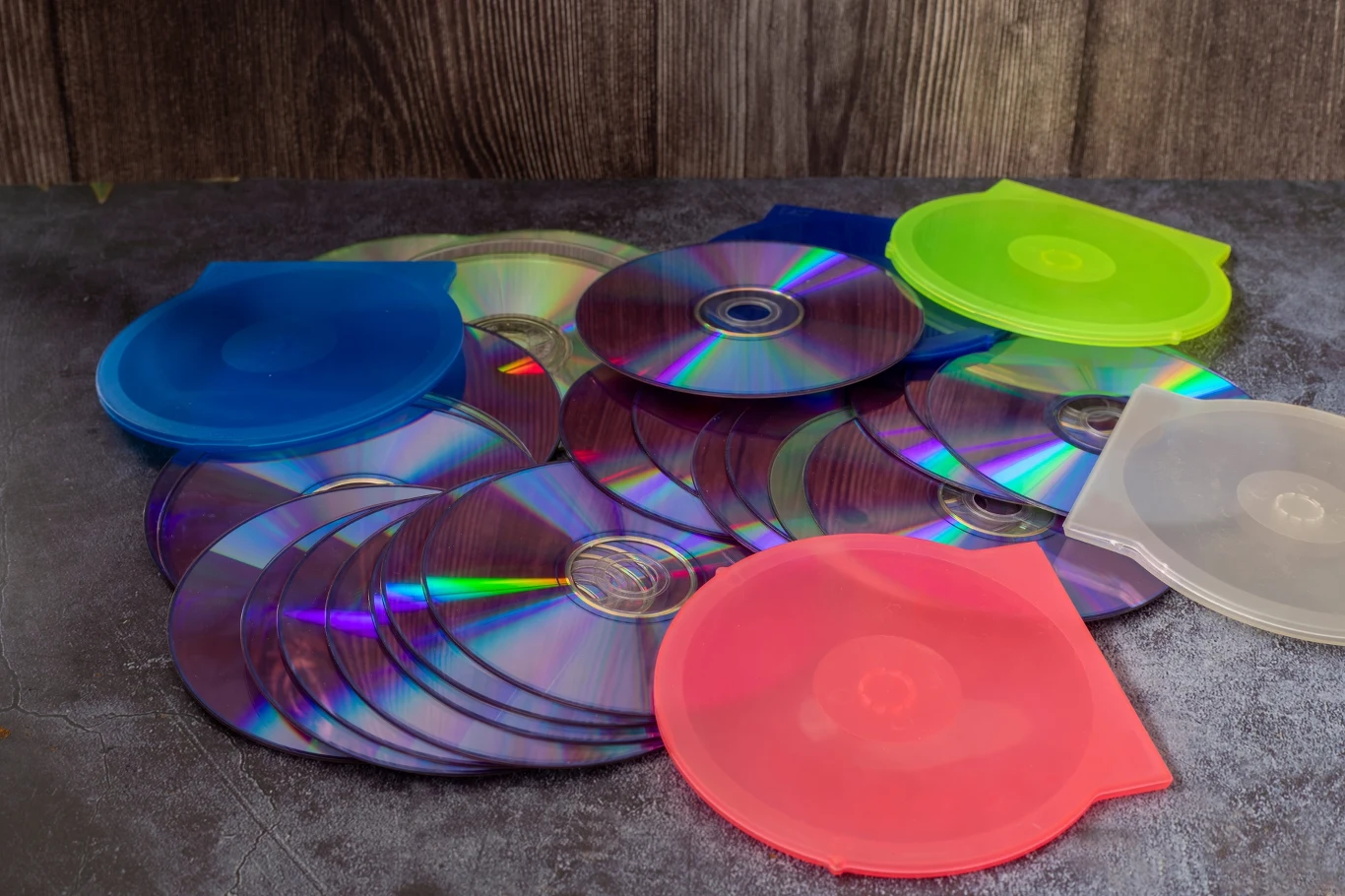 Gdzie wyrzucać płyty CD? To nie są elektrośmieci Stare płyty CD i DVD ułożone na podłodze. Gdzie wyrzucać płyty CD i jak prawidłowo segregować odpady?