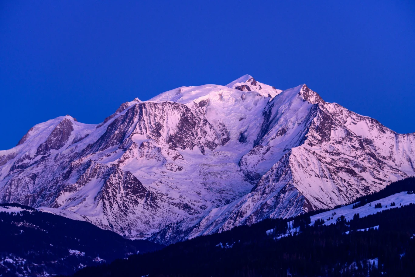Mont Blanc. Zdj. ilustracyjne Mont Blanc - ośnieżone szczyty gór w fioletowym świetle zachodu słońca na tle niebieskiego nieba.