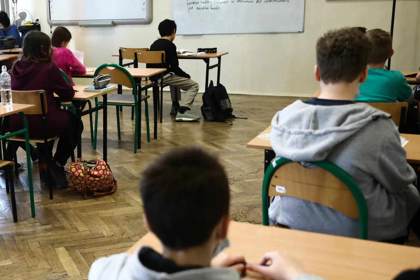 Dzielnicowi z Chojnowa przeprowadzili w lokalnych szkołach prelekcje na temat odpowiedzialności prawnej nieletnich oraz zasad bezpieczeństwa w sieci. Zdjęcie ilustracyjne Uczniowie siedzący w ławkach podczas lekcji w klasie, skierowani w stronę tablicy