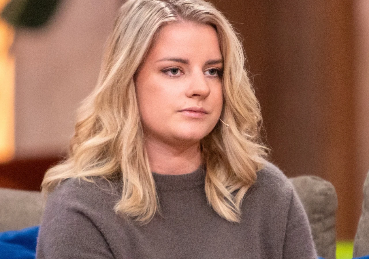 Adrianna Tyszka Adrianna Tyszka z 9. sezonu "Rolnik szuka żony" w brązowym swetrze, siedzi na beżowej kanapie