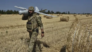 Ukraiński żołnierz z dronem na polu pszenicy. Wojna w Ukrainie ogranicza zbiory