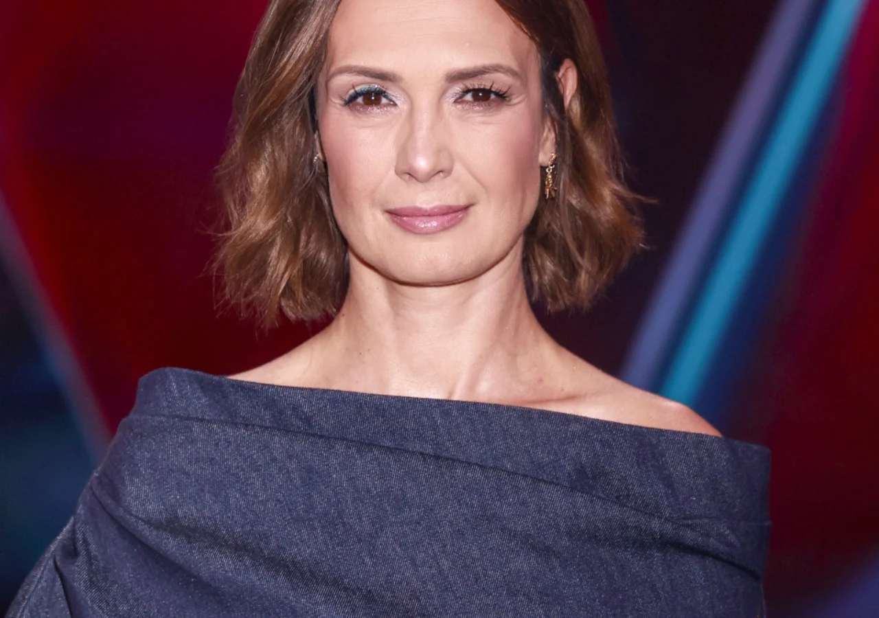 Paulina Chylewska Paulina Chylewska w eleganckiej granatowej kreacji z odsłoniętymi ramionami na tle abstrakcyjnej scenografii.
