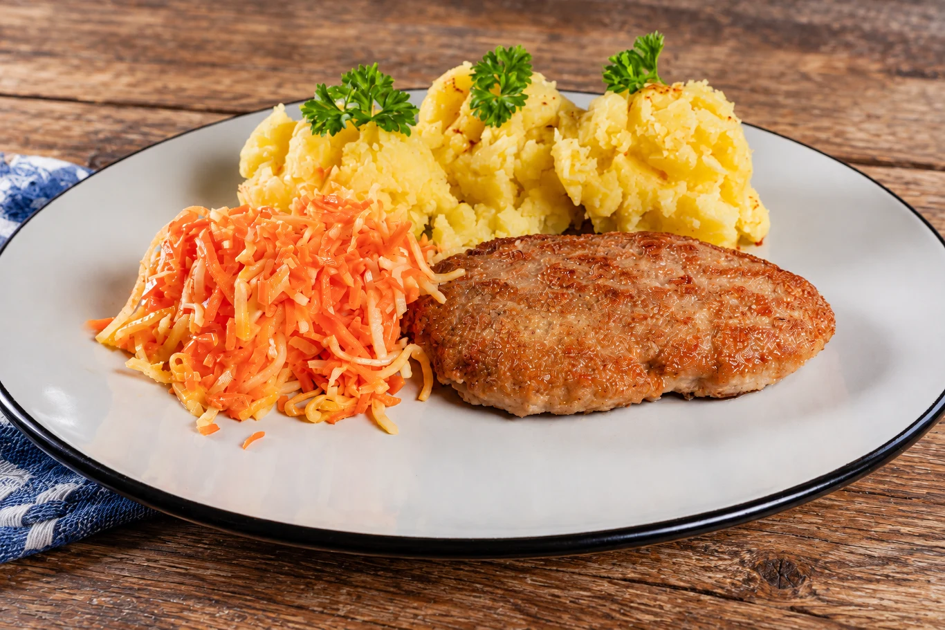 Jak zrobić soczyste kotlety mielone? Dodaj zimną wodę do mięsa kotlet mielony z chrupiącą skórką podany z puree ziemniaczanym z natką i surówką z marchwi i kapusty