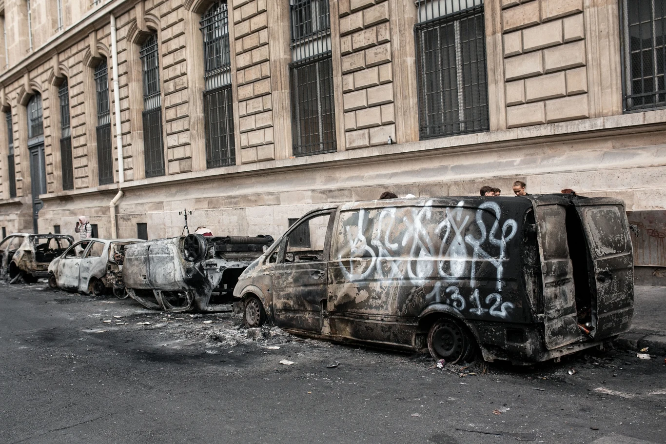 Spalone samochody na ulicach Paryża po gwałtownych zamieszkach Wraki spalonych samochodów i furgonetki pokrytej graffiti w Paryżu, 19 października 2026 roku, po zamieszkach.
