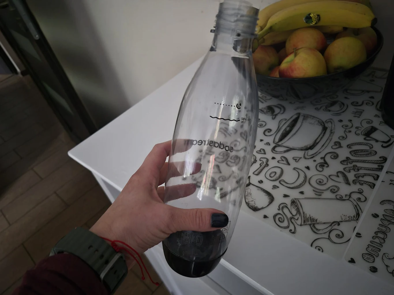 Jak czyścić butelki SodaStream, aby pozbyć się brzydkiego zapachu? Mam sprawdzony trik. Kobieta trzyma pustą butelkę z SodaStream