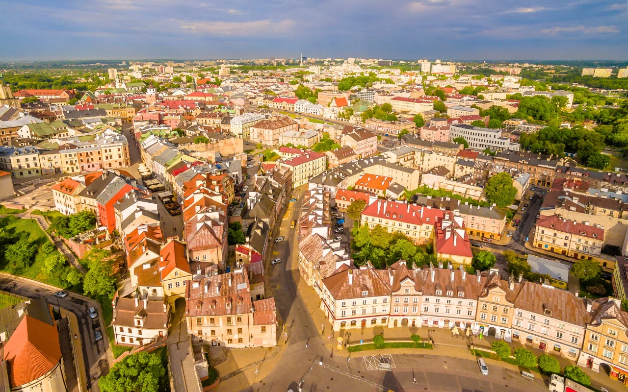Widok z góry na historyczną starówkę w Lublinie z kamienicami o czerwonych dachach i zabytkowymi uliczkami.